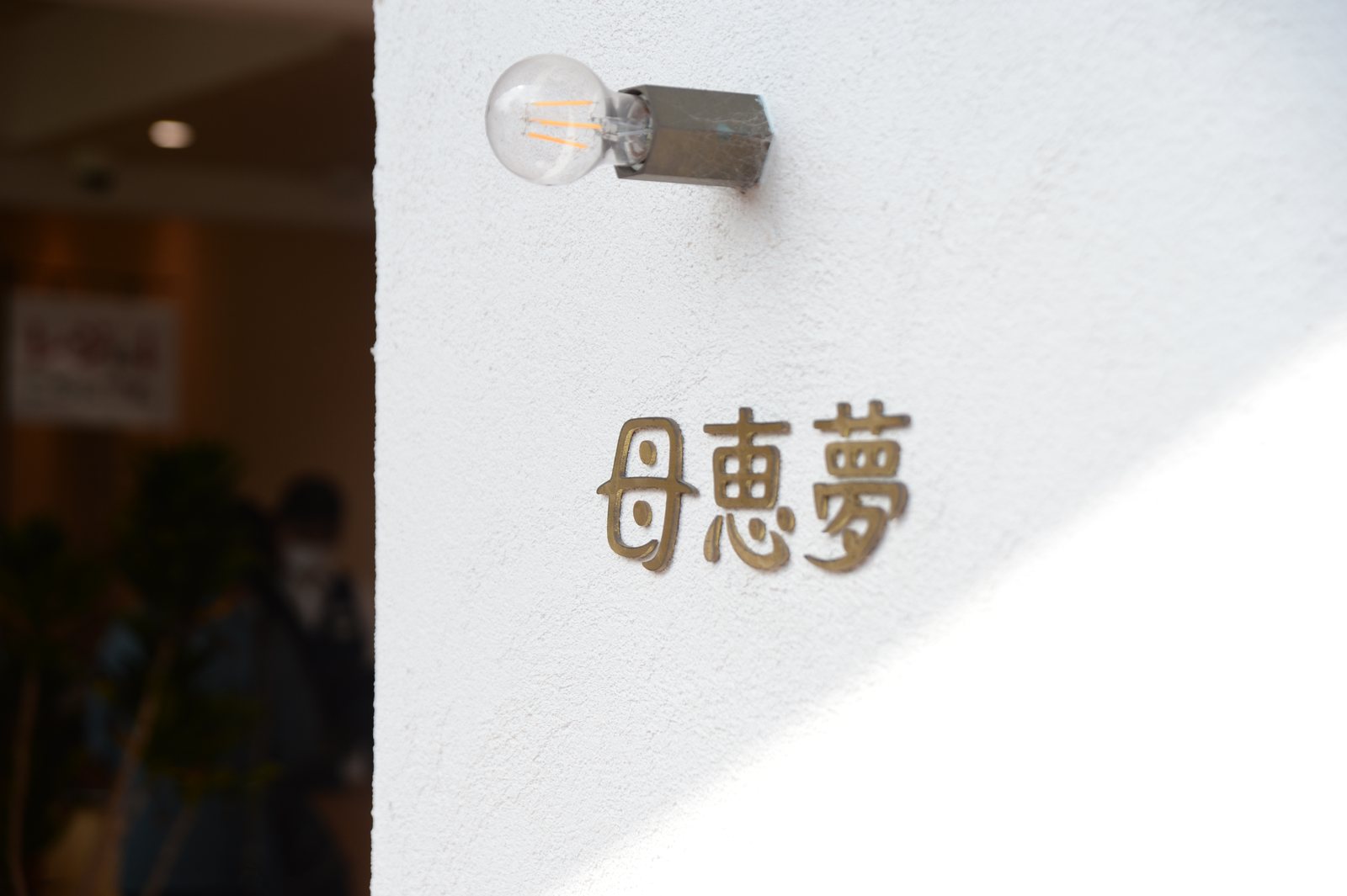 母恵夢本舗の店舗の壁にあるロゴ