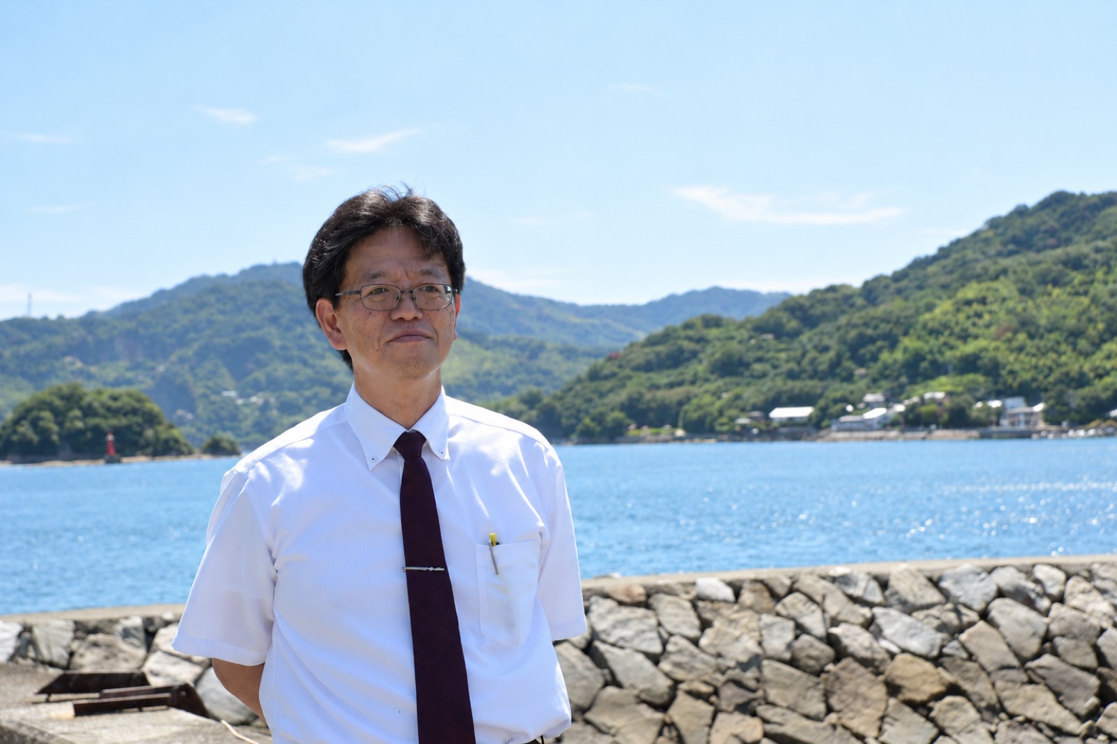 伯方島の海を背景に立つ松浦仁昭さん
