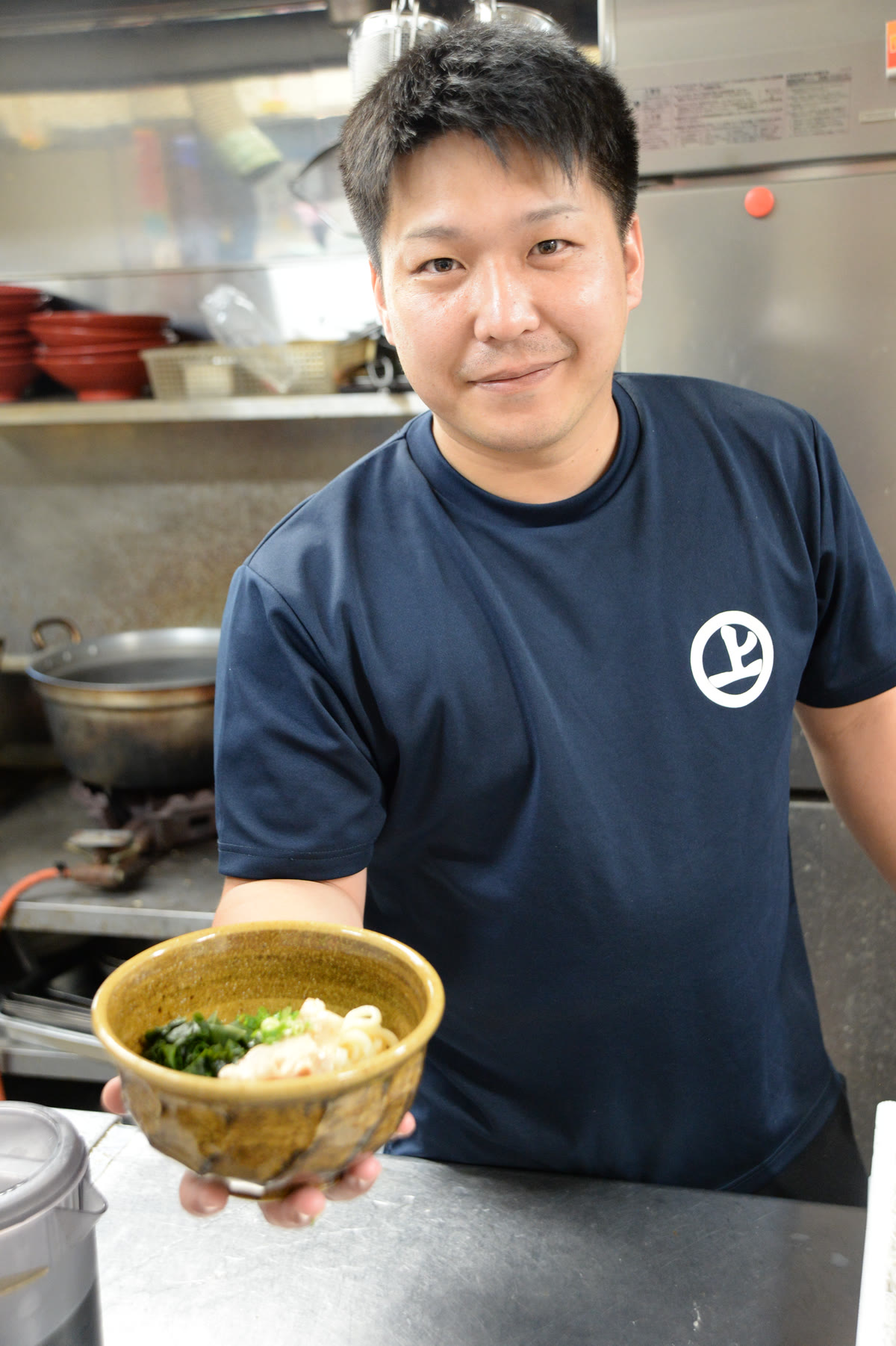 料理を手にする村上泰輝さん