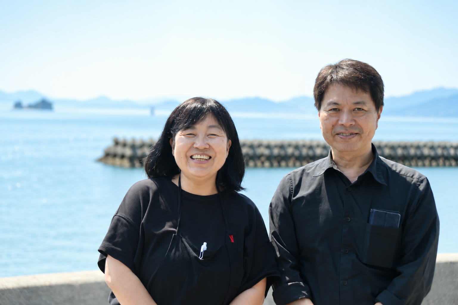 瀬戸内海を背景に立つCafe Shozanの広田裕子さんと俊雄さん